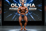 Thefreeway DN109 navy blue laminated competition bodybuilding posing trunks worn by a male bodybuilder on stage in a most muscular pose