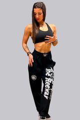 Modella con pantaloni bodybuilding unisex neri Thefreeway con logo bianco sulla gamba